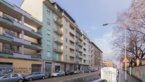 A multi-story residential building with balconies, a street with parked cars, and a pedestrian walkway. - Casa Cecchi by Wonderful Italy (Turin)