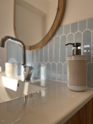 Regadera, secadora de cabello, toallas, papel de baño 