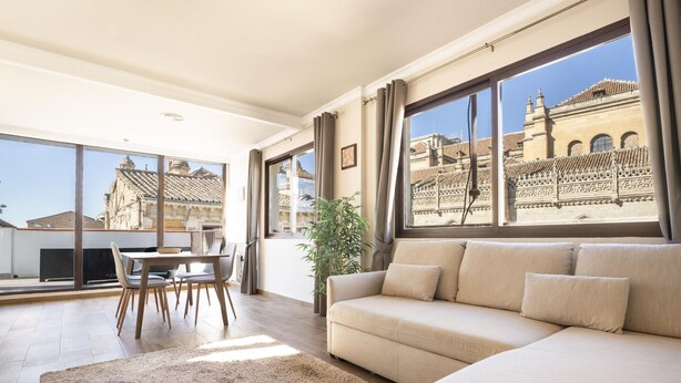A spacious living room with a large window offering a view of a historic building. - Penthouse with terrace in central Granada, stunning views (Granada)