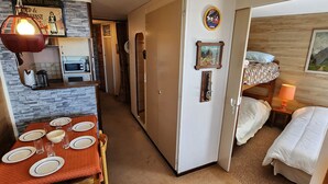 A compact hotel room with a dining area, kitchenette, and a bed with a headboard. - Avoriaz - Cozy apartment for 6, near ski slopes (Avoriaz)