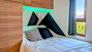 Une chambre à coucher avec un lit, une fenêtre avec des rideaux et des armoires en bois.