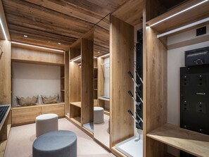 A modern walk-in closet with wooden shelving, a wine rack, and a Koralp appliance. - Modern chalet in Courchevel with sauna and jacuzzi (Courchevel 1550)
