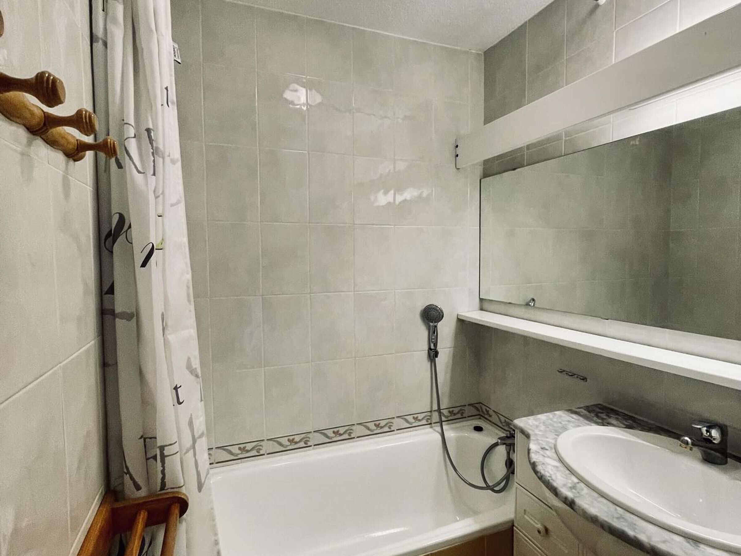 A bathroom with a bathtub, a shower, a sink, and a mirror.