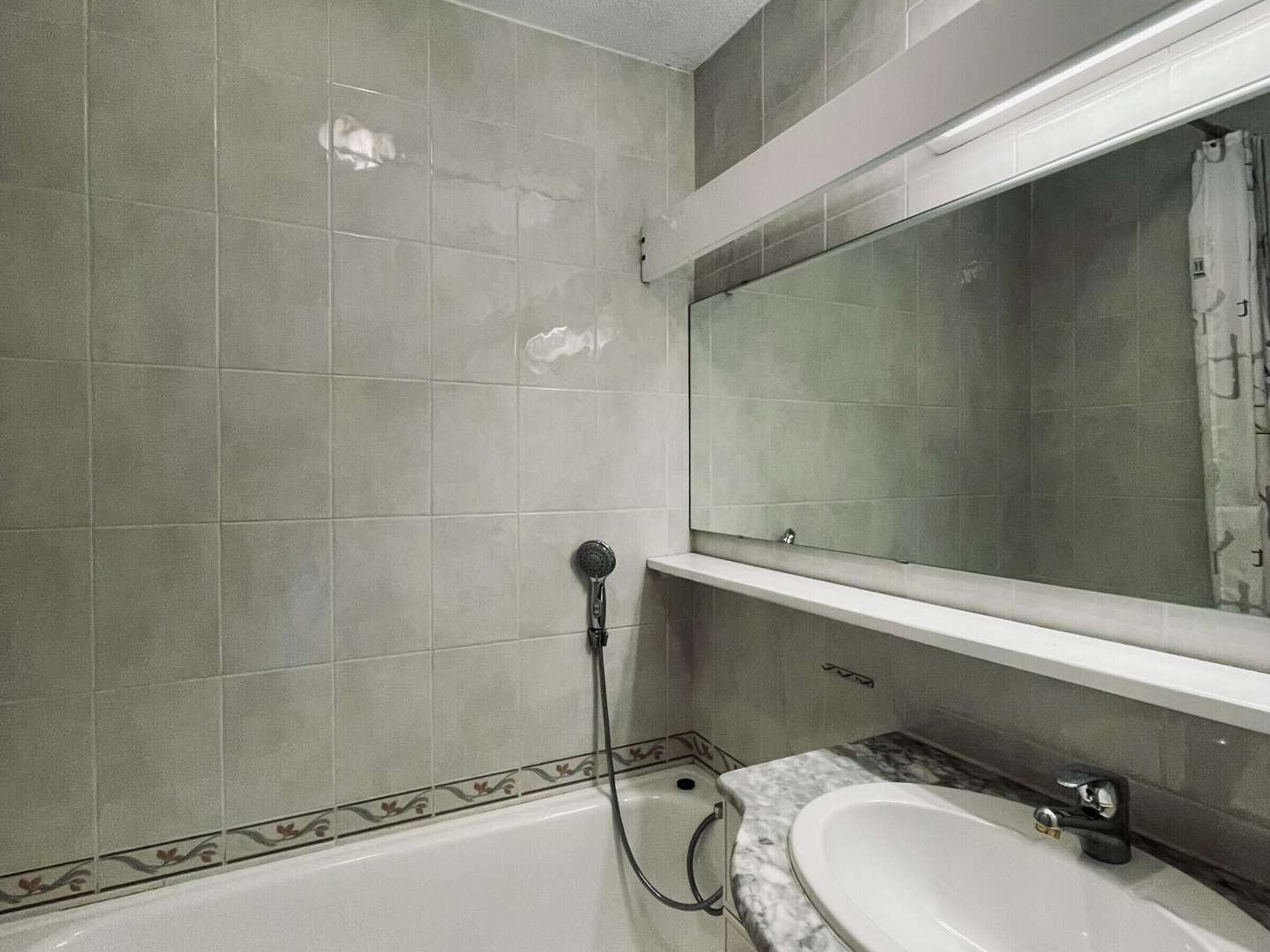 Un bagno con una vasca, un lavandino e uno specchio.