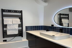 Een douche, handdoeken, zeep, toiletpapier