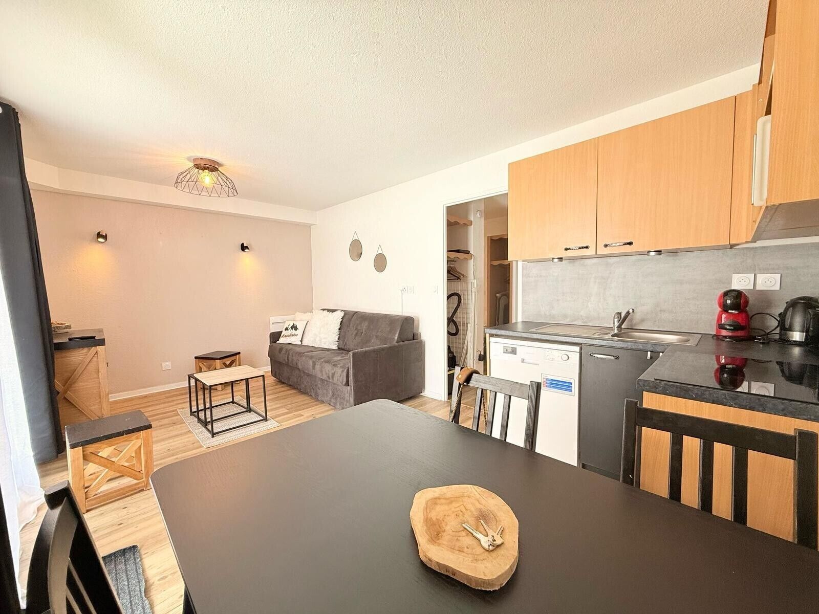 A compact living space with a kitchenette, a dining area, and a sofa.