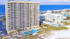 A high-rise hotel with multiple balconies, a swimming pool, and a beach view. - Gulf Front Upscale 2BR Condo | Sleeps 6 | 2 Pools | Hot Tub (Pensacola Beach)