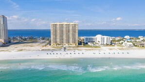 A coastal hotel with multiple high-rise buildings, a sandy beach, and clear blue waters. - Gulf Front Upscale 2BR Condo | Sleeps 6 | 2 Pools | Hot Tub (Pensacola Beach)