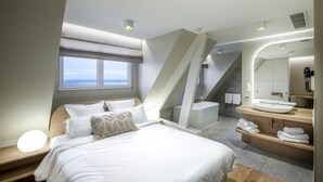 A modern bedroom with a large bed, a bathroom with a bathtub, and a view of the sky through a window. - Face à La Mer Gravelines  (Gravelines)