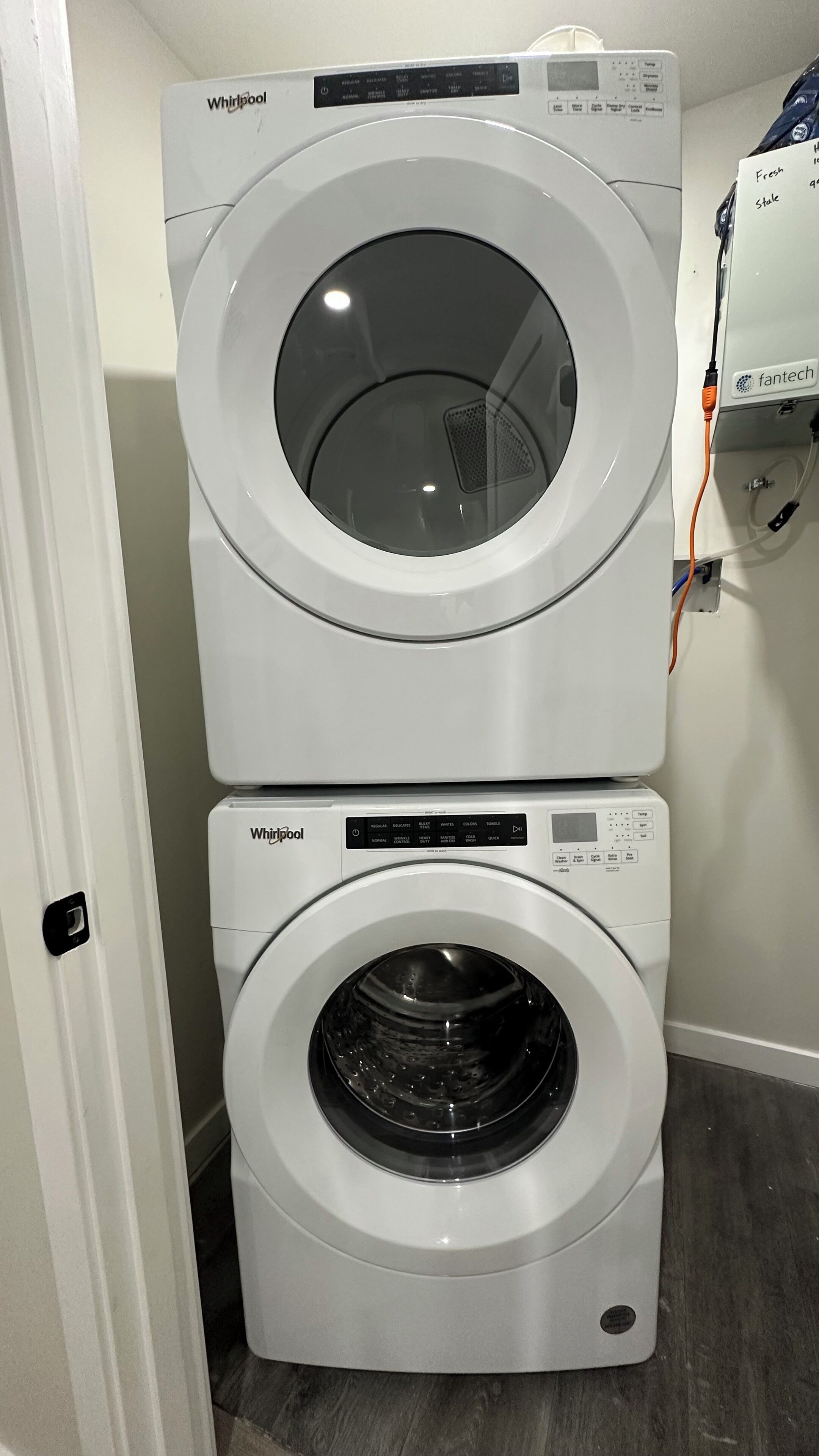 Deux machines à laver Whirlpool superposées dans une buanderie.