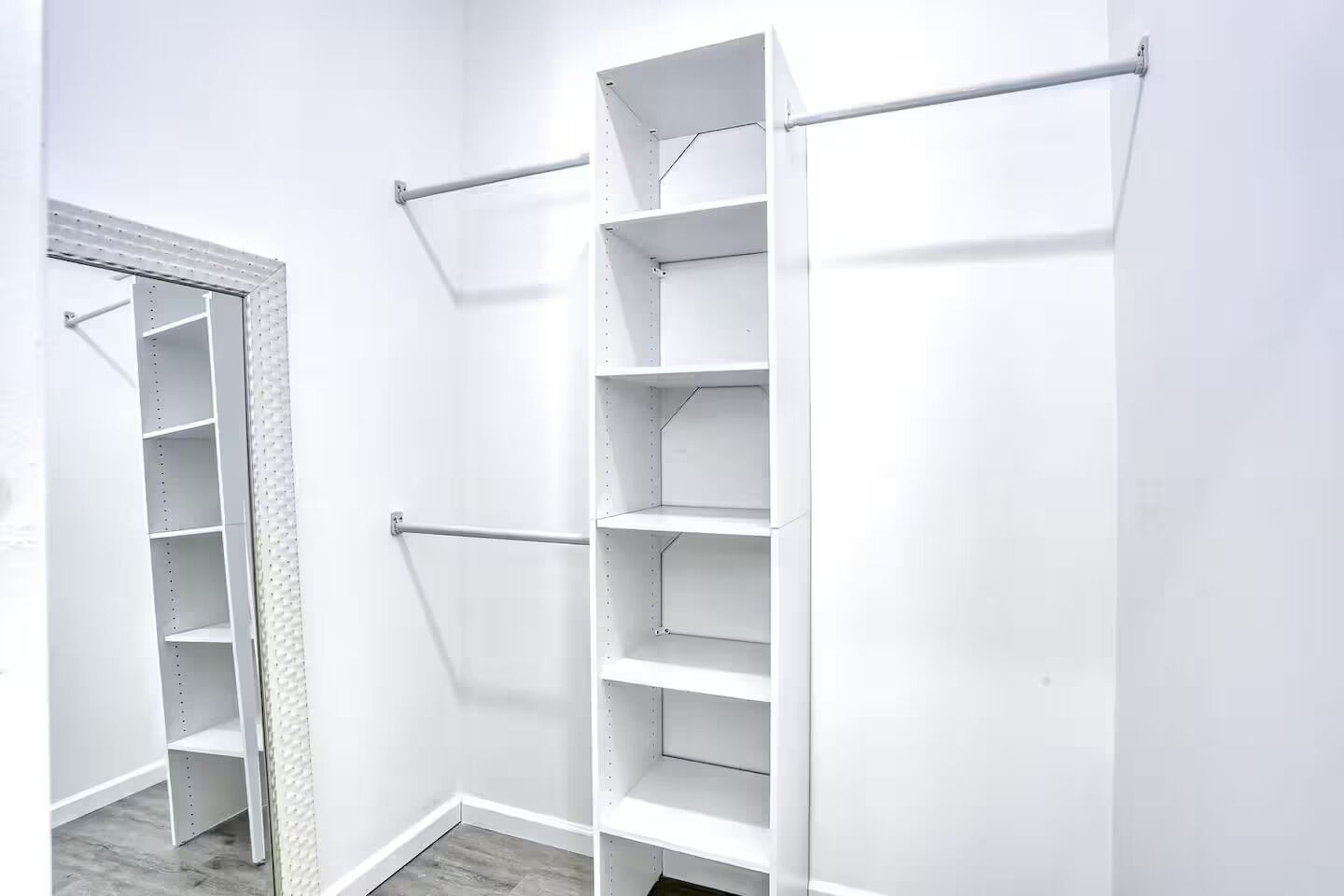 A white closet with multiple shelves and a hanging rod.