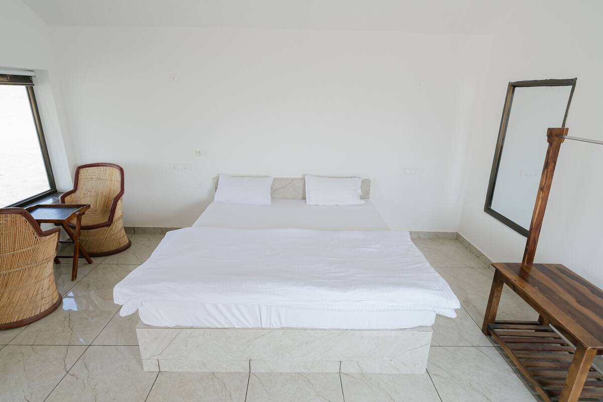 Ein Hotelzimmer mit einem großen Bett, einem Schreibtisch mit Stuhl und einem Fernseher auf einem Tisch.