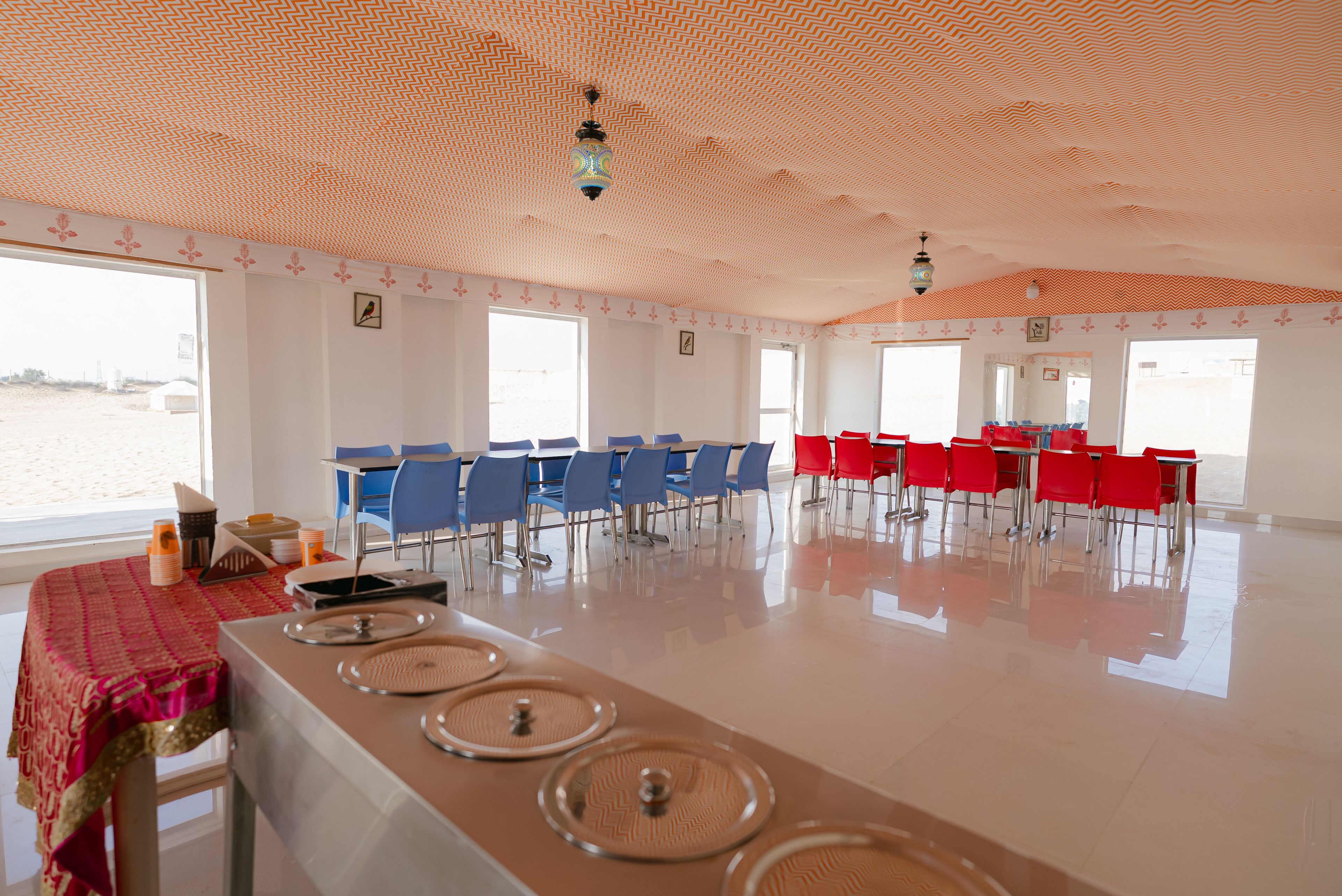 A spacious room with a long table, multiple chairs, and a view of the water outside.