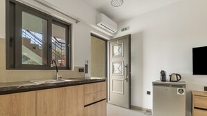 A modern kitchen with a wooden countertop, stainless steel appliances, and a built-in oven. - Studio Apartment 'Sokol Stone House 2' with Mountain View, Wi-Fi and Air Conditioning (Ελλομένο)