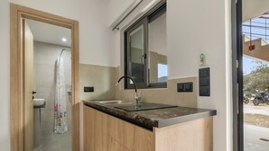 A modern kitchen with a sink, wooden cabinets, and a window. - Studio Apartment 'Sokol Stone House 2' with Mountain View, Wi-Fi and Air Conditioning (Ελλομένο)