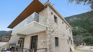 A stone building with a balcony, a staircase, and a view of the surrounding landscape. - Studio Apartment 'Sokol Stone House 2' with Mountain View, Wi-Fi and Air Conditioning (Ελλομένο)