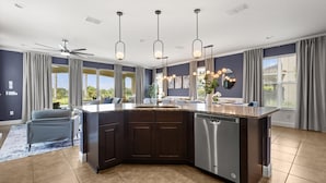 A modern kitchen with a central island, dark cabinetry, and a dishwasher. - Upstay Spacious 5BR Villa Private Pool and Hot Tub (Kissimmee)