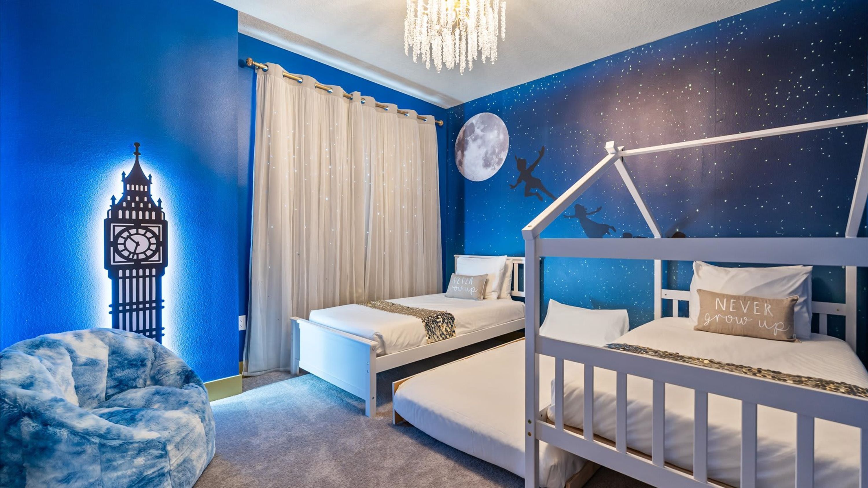 A bedroom with a bunk bed, a daybed, a wall clock, a moon mural, and a starry night sky mural.