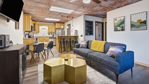 Ein modernes Wohnzimmer mit Sofa, Couchtisch und Fernseher.