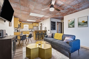 A modern living room with a sofa, coffee table, and TV. - Jewels in the Ridge - Hot Tub, Fire Pit, Privacy (Blue Ridge)