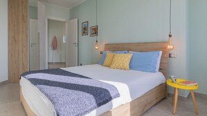 A bedroom with a bed, bedside table, and a door.