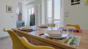 A dining area with a wooden table, yellow chairs, and a kitchen in the background.