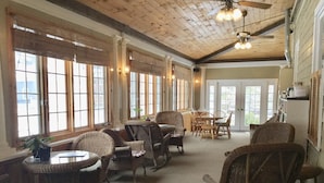 A spacious room with wicker furniture, large windows, and a ceiling fan. - Crafts Inn, Hotel Suite with pool and hot tub. (Wilmington)