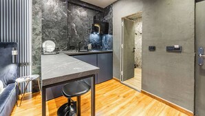 A modern kitchen with a marble countertop, a built-in stove, and a sink.