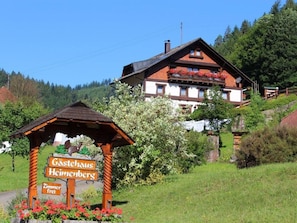 A traditional wooden building with a sign indicating 'Gästehaus Heimenbergs' and 'Zimmer frei' (rooms available).
