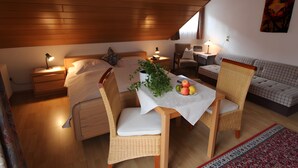 Une pièce confortable avec un lit, une table à manger et des chaises, un petit bureau et un canapé.