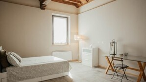 A bedroom with a bed, a desk, a chair, a window, and a radiator. - Holiday Home 'La Cocca Home' with Shared Garden and Wi-Fi (Bellinzago Novarese)