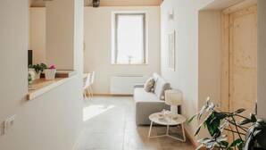 A modern living room with a sofa, a dining table, and a window. - Holiday Home 'La Cocca Home' with Shared Garden and Wi-Fi (Bellinzago Novarese)