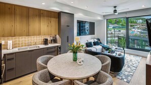 A modern kitchen with a marble island, dark cabinetry, and a large window offering a city view. - Modern 2 bedroom 2 bathroom Ski In&Ski Out 07 (Snowmass Village)