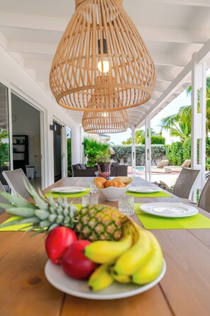 Un comedor con una mesa de madera, platos y un cuenco de fruta.
