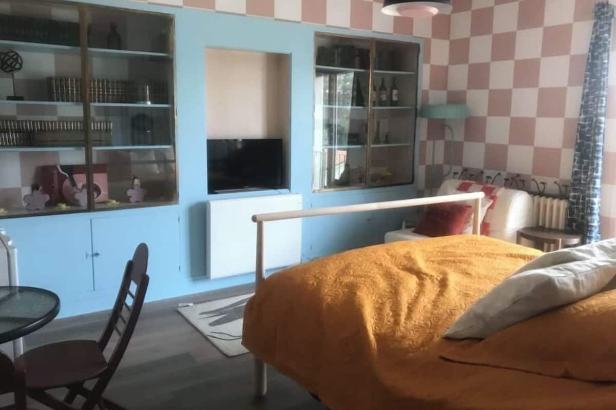 Ένα υπνοδωμάτιο με ένα κρεβάτι, ένα γραφείο και μια καρέκλα. Υπάρχει ένα παράθυρο με θέα προς τα έξω.
