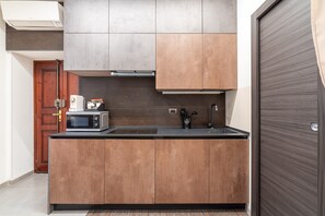 Une cuisine compacte équipée d’un four à micro-ondes, d’un évier et de placards.
