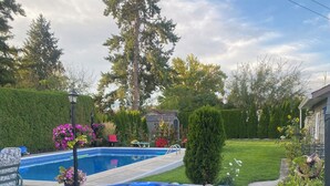 Ein Garten mit Whirlpool, Schwimmbad und gepflegtem Rasen.