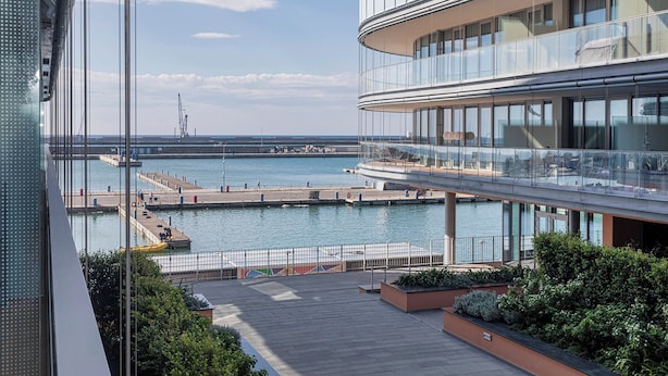 Un edificio moderno con fachada de vidrio que da al paseo marítimo.