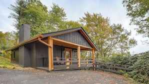 A cabin with a wooden deck, a chimney, and a porch. - Chic Cabin! Epic Views of Grandfather Mountain (Blowing Rock)