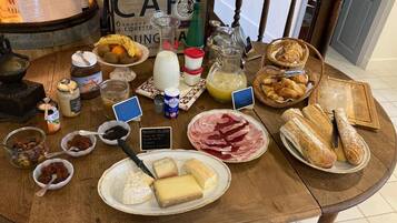 Une table de petit-déjeuner avec divers aliments, notamment du fromage, du pain et des condiments.