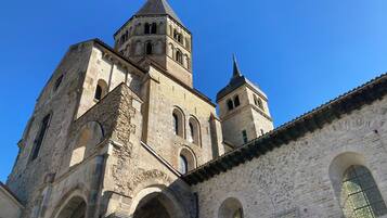 A historic stone building with multiple arches and a prominent bell tower.