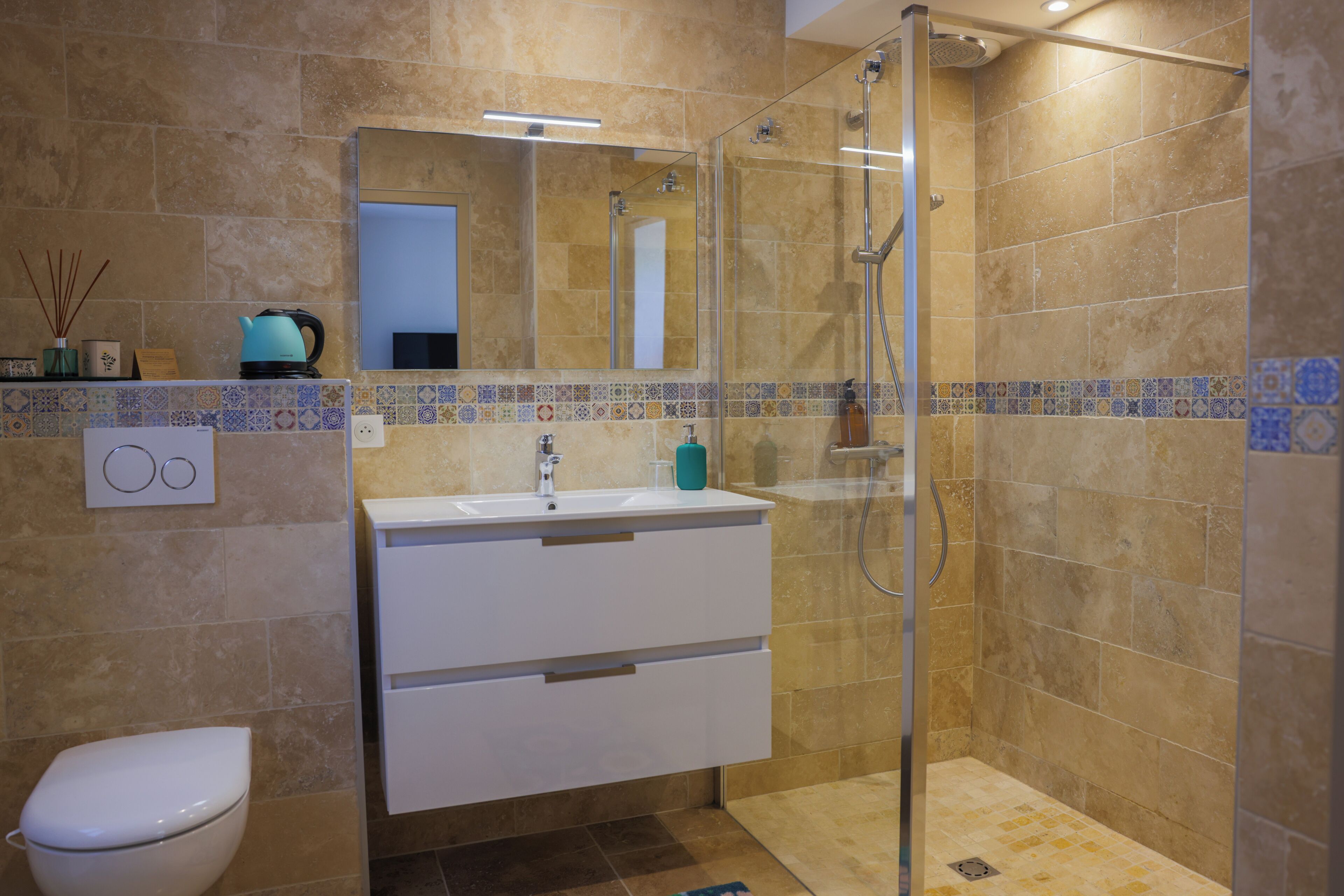 Un baño con ducha acristalada, un lavabo blanco y un inodoro.
