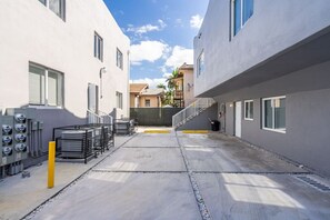 A narrow alleyway with a concrete floor, surrounded by buildings with large windows and a staircase leading to a second level. - ° Cozy Private 2 BR Apt 5min to Brickell  8th st ° (Miami)