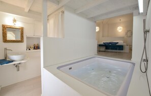 Un baño moderno con una bañera grande, un lavabo y una ducha.