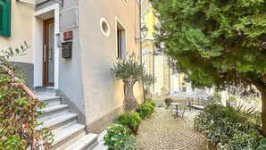 A courtyard with a cobblestone path, a wooden staircase, and a small outdoor seating area. - 1 bedroom gorgeous apartment in Pieve di Teco (Pieve di Teco)