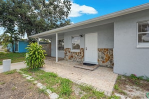 A house with a covered porch, a stone wall, and a door. - Florida Retreat 3 miles IMG 10 Miles Beach (Bradenton)