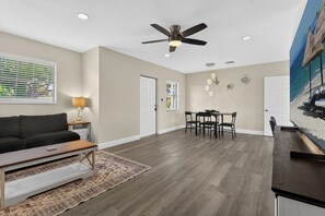 A spacious living area with a ceiling fan, a dining table with chairs, a sofa, and a coffee table. - Florida Retreat 3 miles IMG 10 Miles Beach (Bradenton)