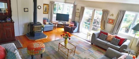 A living room with a sofa, ottoman, and a television.