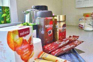 A kitchen counter with various food items including a box of red seal blood orange juice, Nescafé Gold instant coffee, and chocolate bars. - Magpie Cottage - Homestay B&B (Taumarunui)