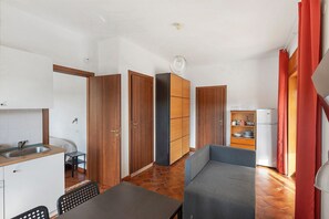 A compact kitchen with a sink, a dining table, and a sofa. - Libeccio Sea View Apartment with Wi-Fi and Air Conditioning (Agropoli)